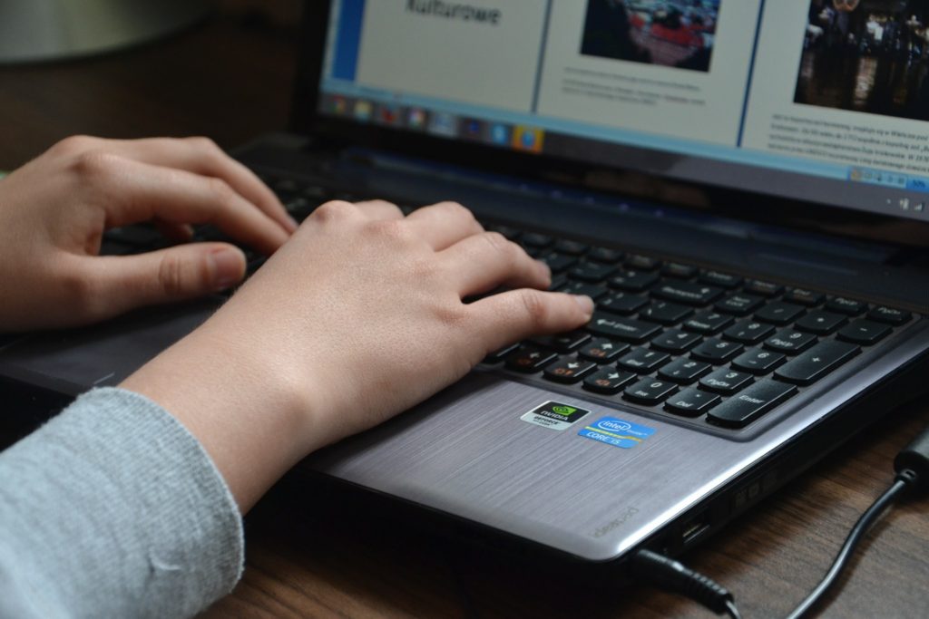 Hands typing on a laptop