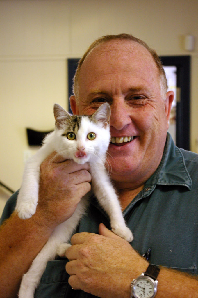 Smiling man holding a kitten