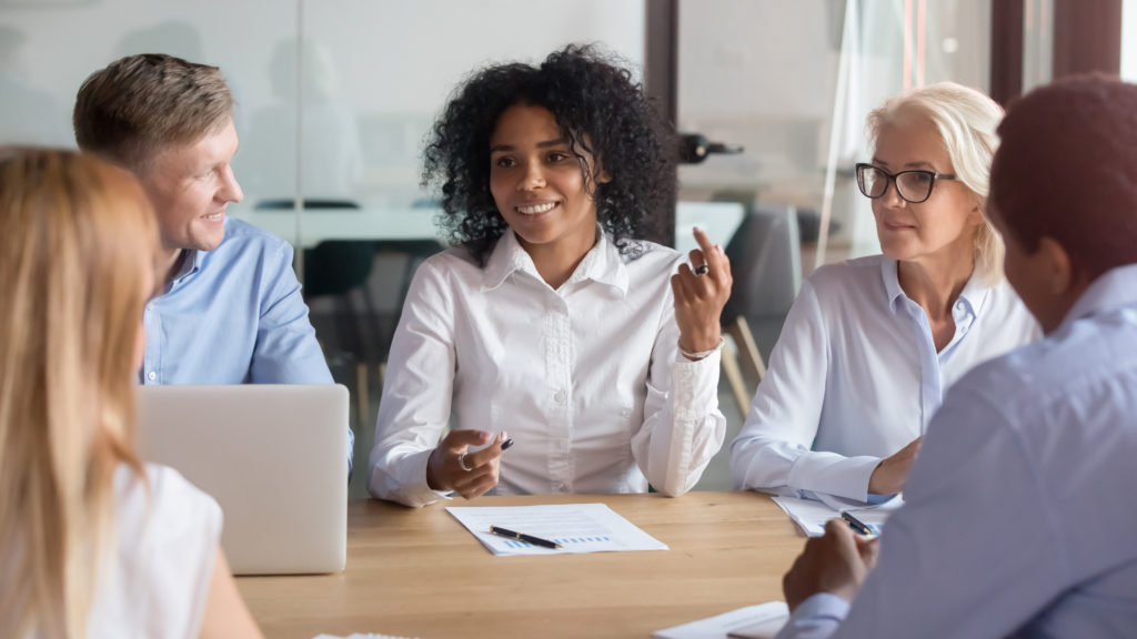 Group of people sitting in a boardroom talking