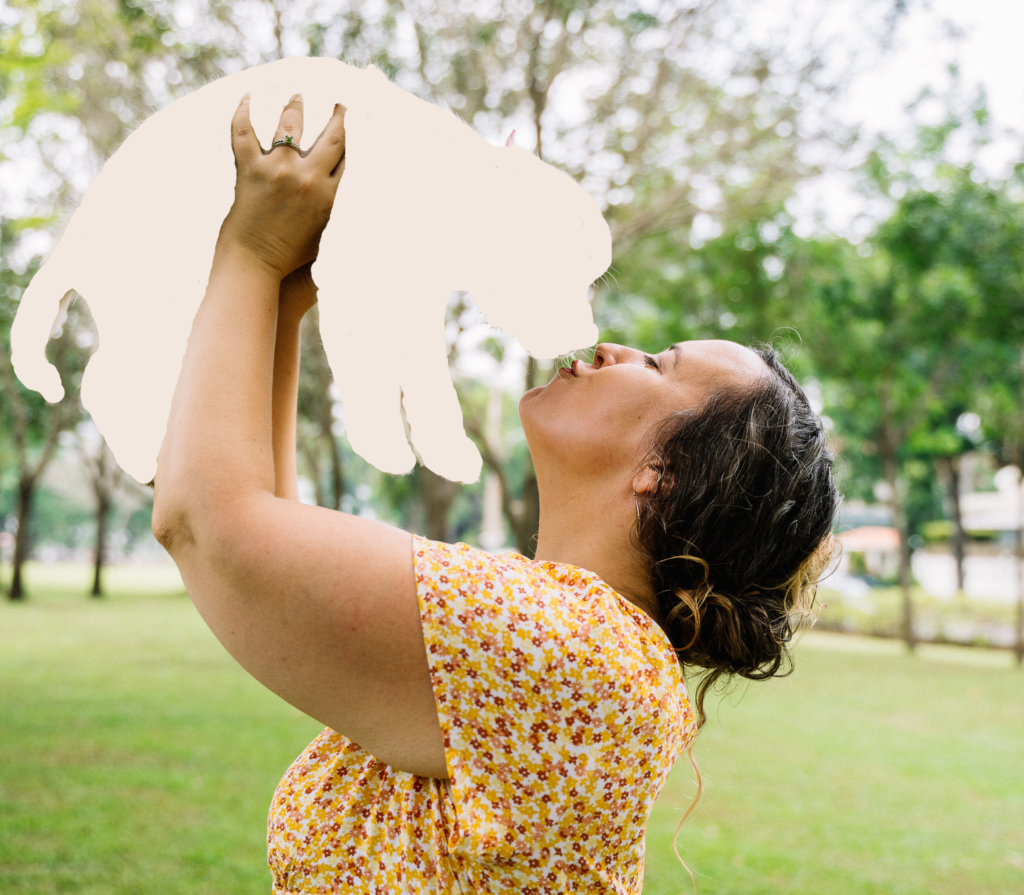 woman lifting up the sillouette of a puppy