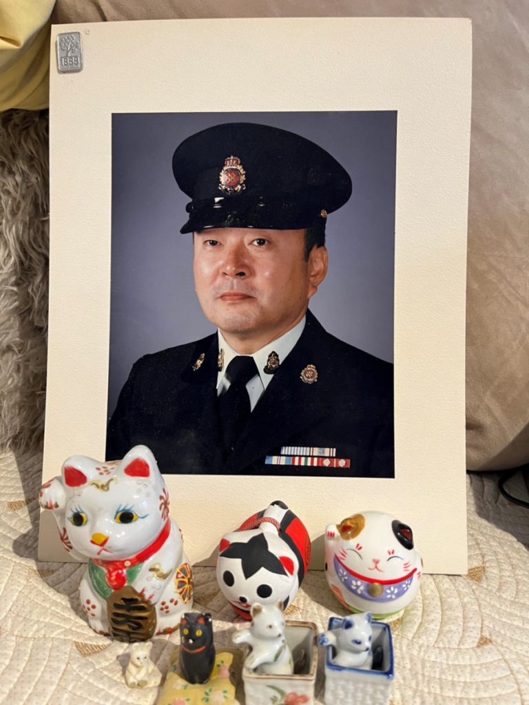 A portrait of James Ito with maneki-neko (beckoning cat) a Japanese figurine which is believed to bring good luck to the owner.