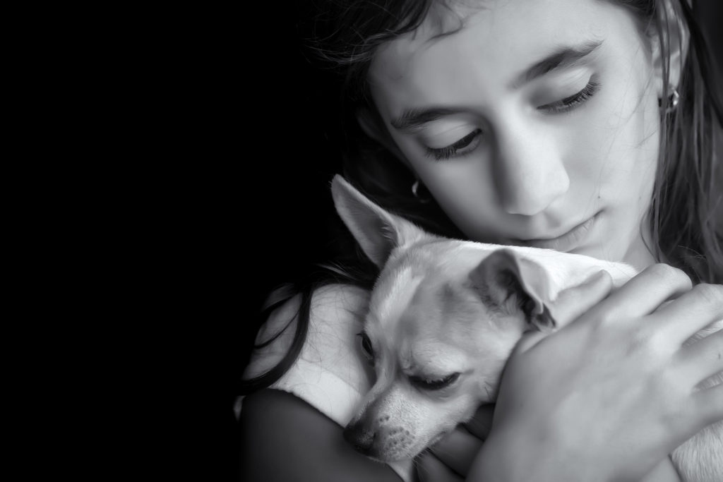 Sad lonely girl hugging her small dog